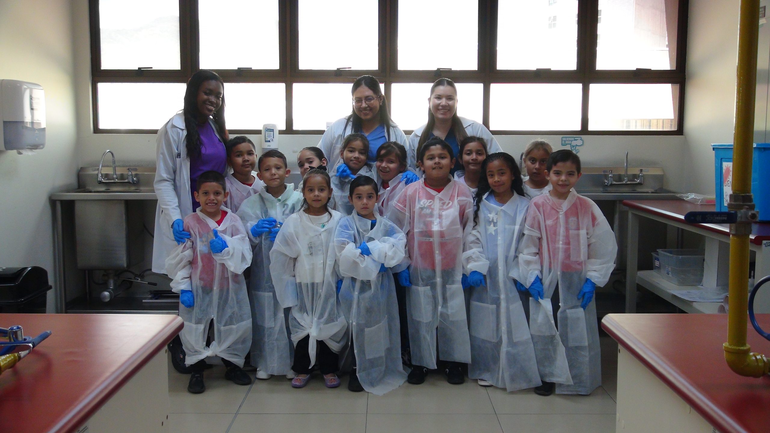 Estudiantes de Microbiología UCIMED con los niños del Kinder Gato con Botas